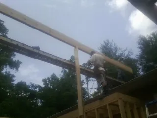 Carpenter setting a ridge beam over a new addition frame — Ice Dam Removal by Roofing Brothers in Carleton