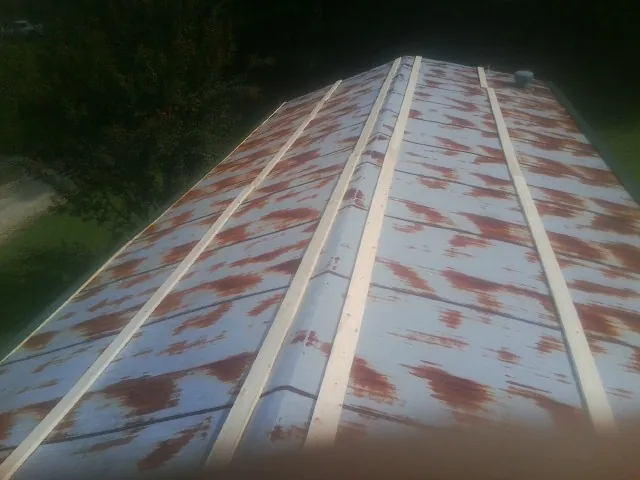 Rusted metal roof panels with new wood purlins before replacement — Storm Damage Roof Repair in Carleton by Roofing Brothers